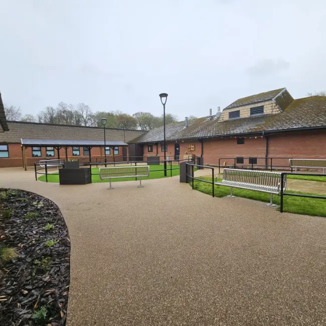 Resin bound pathway with seating and accessible walkways in care home courtyard