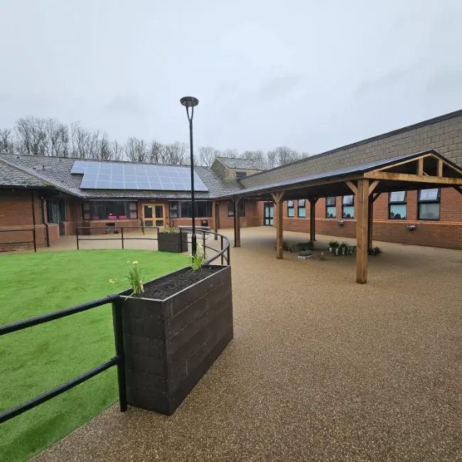 Commercial resin bound surfacing with canopy seating area and accessible pathways at care home