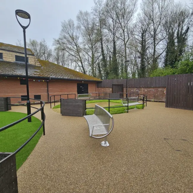 Resin bound courtyard with accessible pathways and seating area at care home