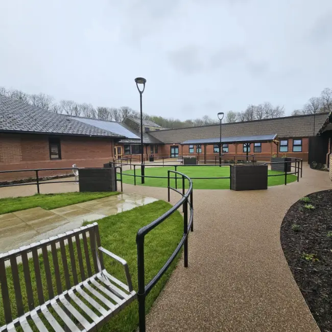 Commercial resin bound surfacing at care home courtyard with pathways and seating in the North West