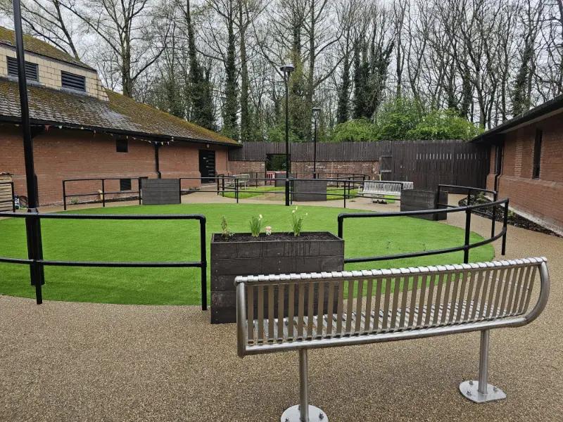 Resin bound courtyard with seating and central green space in care home
